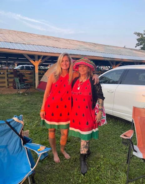 Two women wearing matching Watermelon-themed dresses