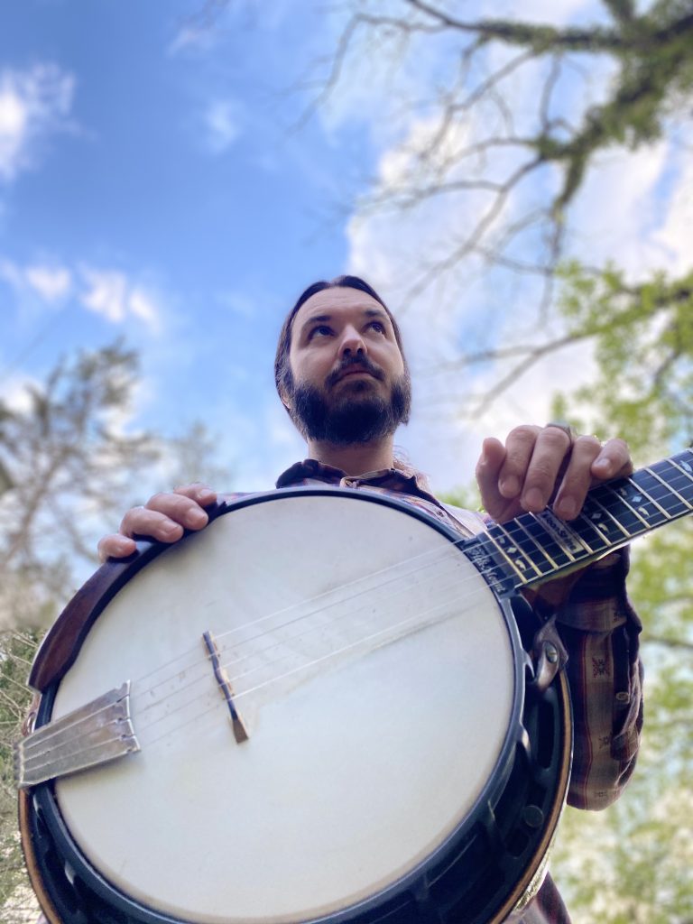 Derek Kretzer holding a banjo