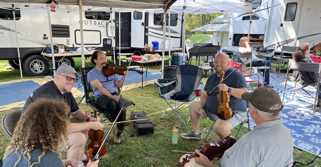 Workshop Fiddles fiddlers seated in a circle at a camp at the Watermelon Workshop Music Camp