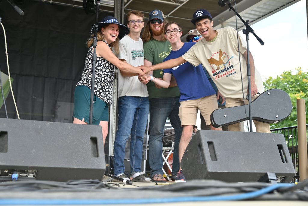 Sheep and Goats Band – photo by Kevin Slick The Sheep and Goats smile for a photo with Tara Linhardt after winning the Watermelon Band Contest
